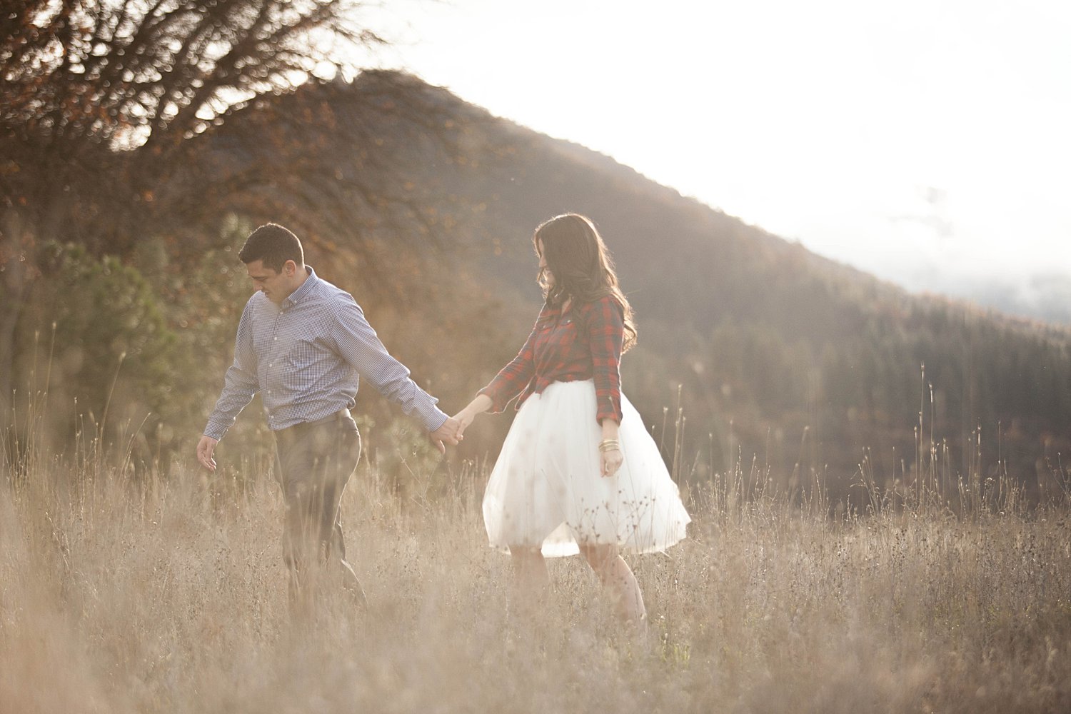 couple holding hands in foggy field