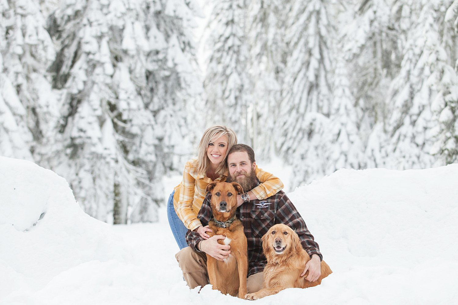 cute couple with dogs in the snow