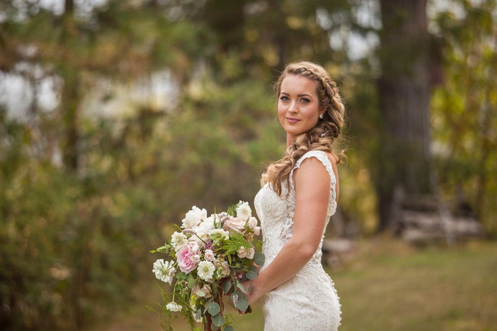 bride with long braid holding bouquet