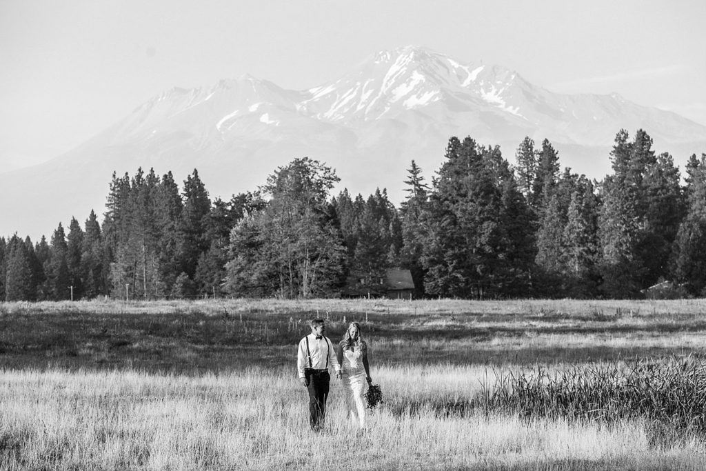 newlyweds walking in front of mount shasta