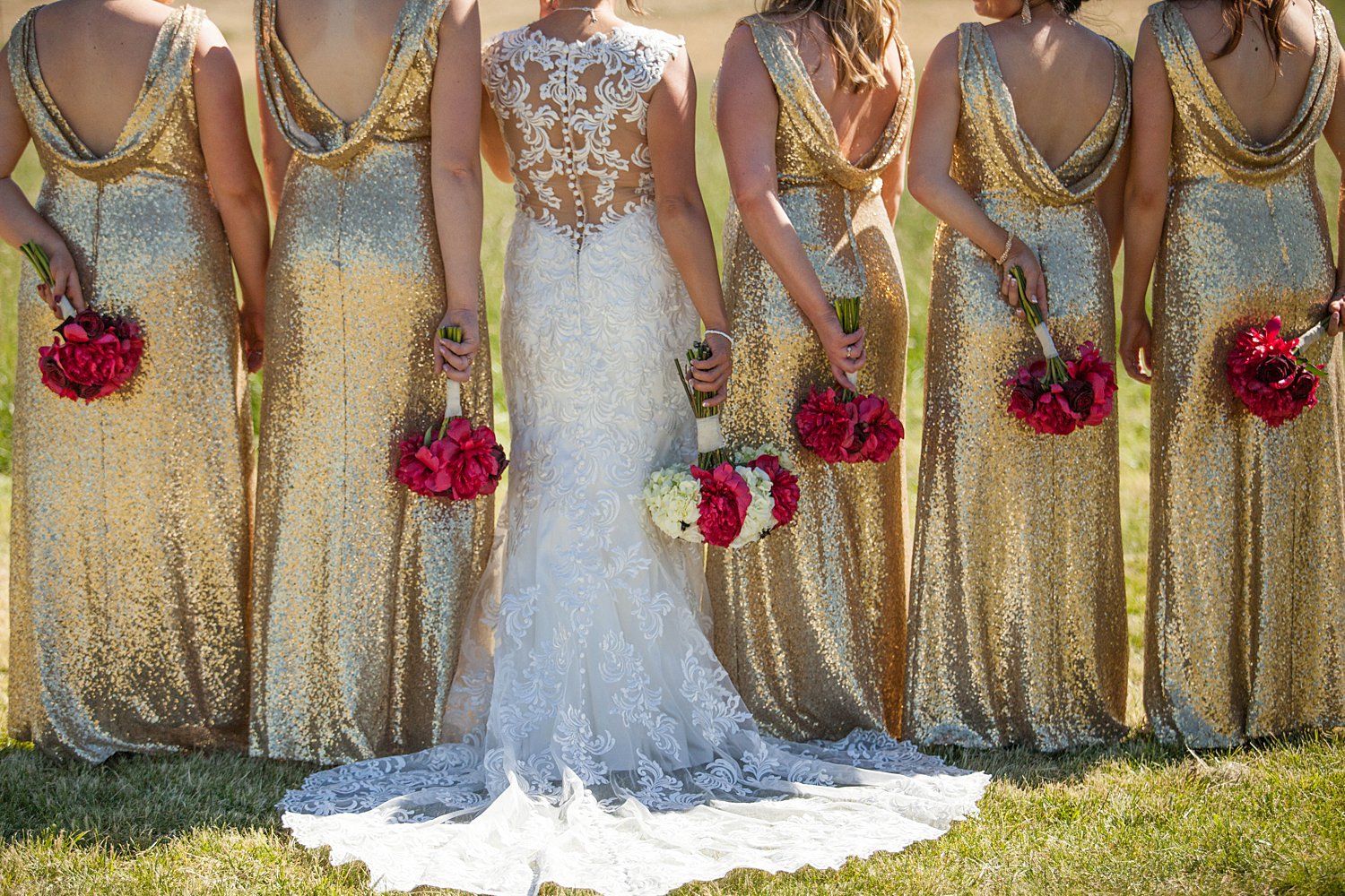 bridesmaids wearing gold sparkly gowns holding red bouquets