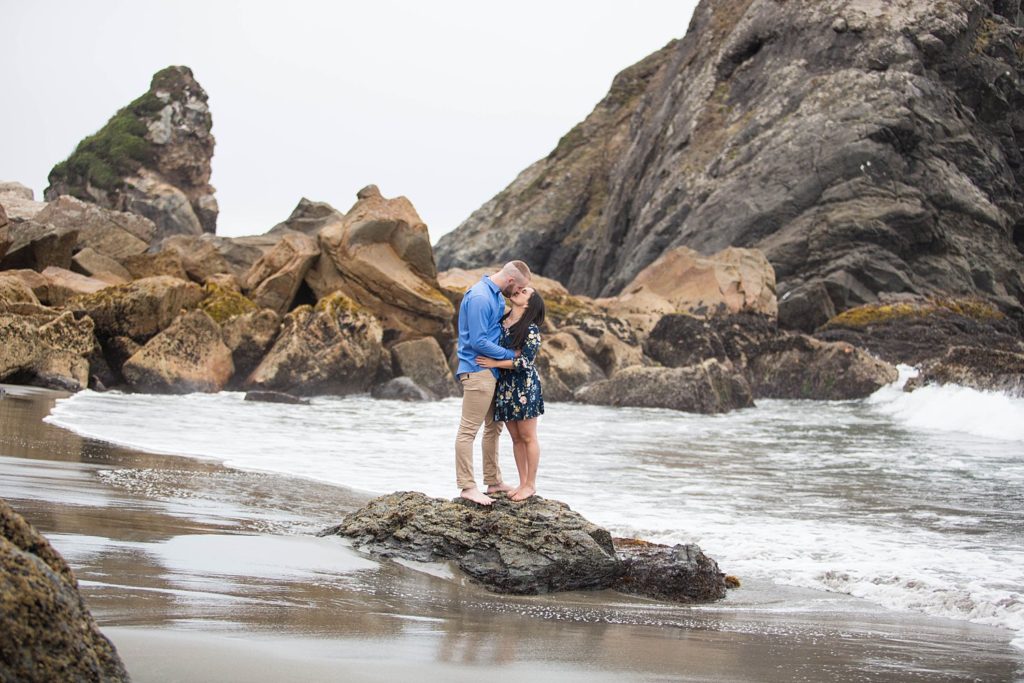 couple kissing on rocks on Oregon coast