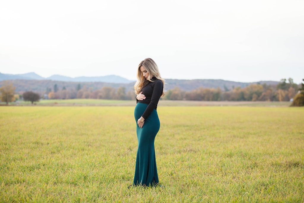 pregnant woman holding tummy in a pretty green gown