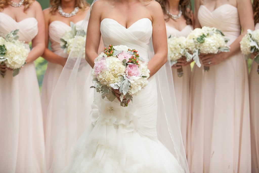 bridesmaids blush colored dresses with cream bouquets