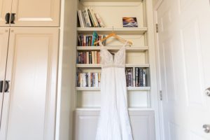 wedding dress hanging on book shelf