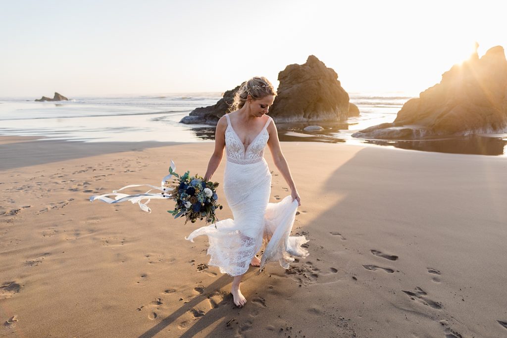 Bride twirling her dress on the beach as the sun sets