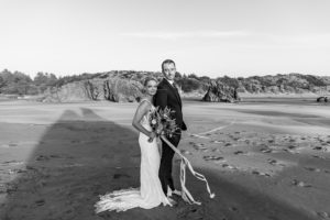 bride and groom on a windy beach on wedding day