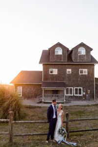 Newlyweds at sunset next to beach house